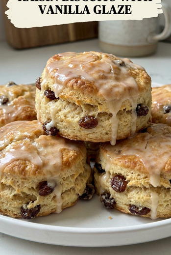 Freshly baked cinnamon raisin biscuits drizzled with vanilla glaze on a wire cooling rack